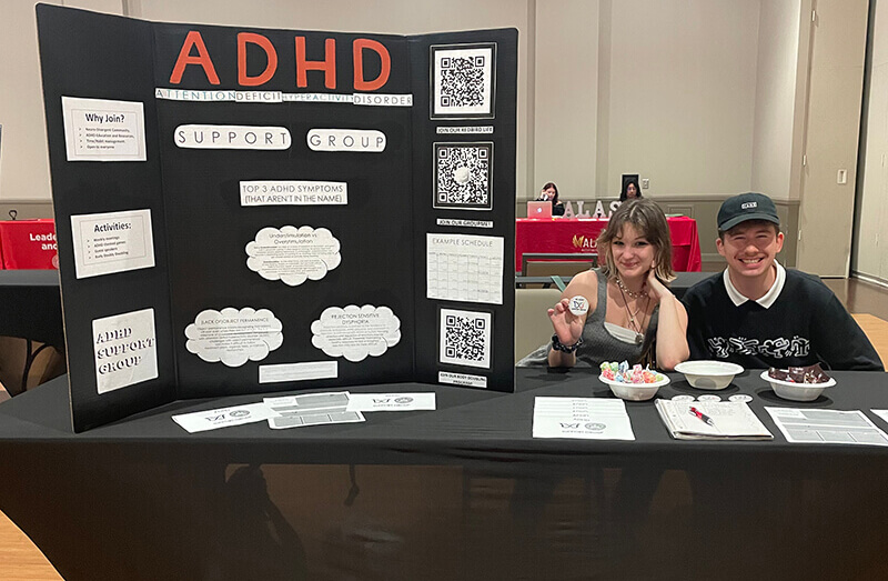 Students at a table displaying information on ADHD.
